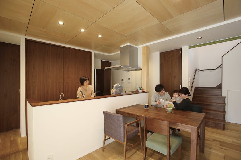 LDKの造作家具はウォールナットで統一。天井はシナベニヤ、床はナラを採用している。対面キッチンなので、キッチンに立ちながら、ダイニングにいる家族とコミュニケーションがとれる。